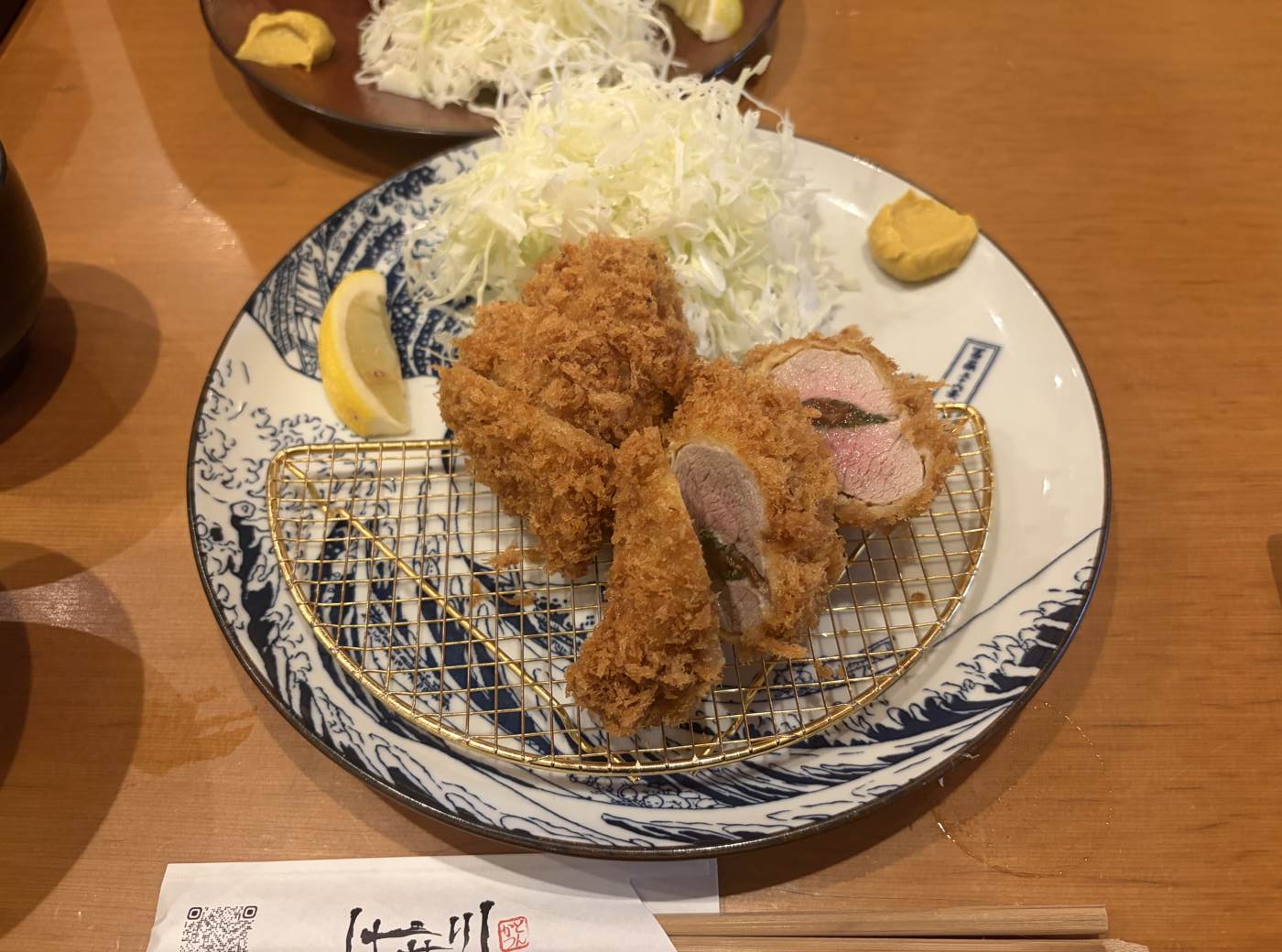 はせ川とんかつの断面。しそを挟んだ上ロースはほんのりピンク色で、衣はきめ細かくサクサク